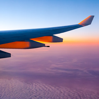 Blick aus dem Flugzeug auf das Morgenrot ber den Wolken mit A330 Tragflche