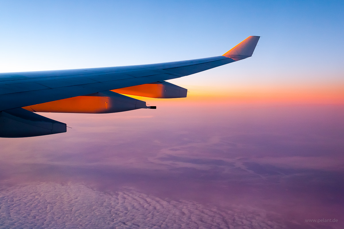 Blick aus dem Flugzeug auf das Morgenrot ber den Wolken mit A330 Tragflche