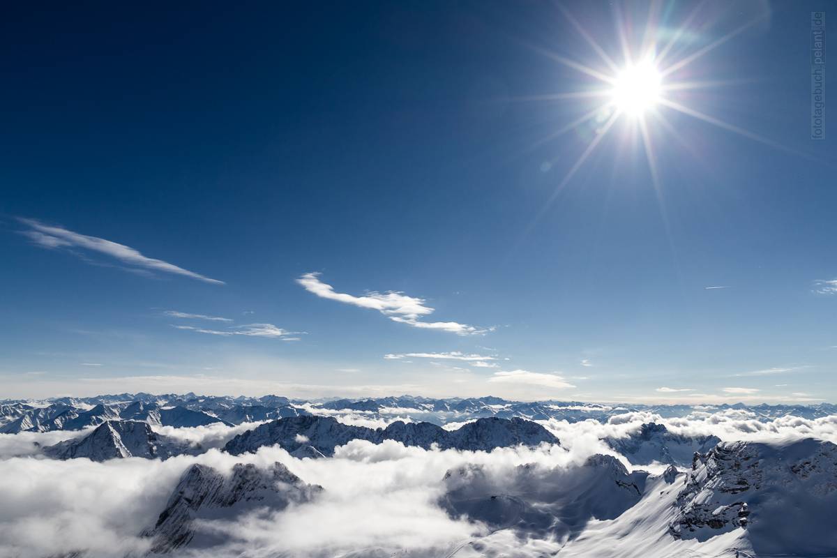 blauer Himmel und Berge in den Wolken (Alpen)