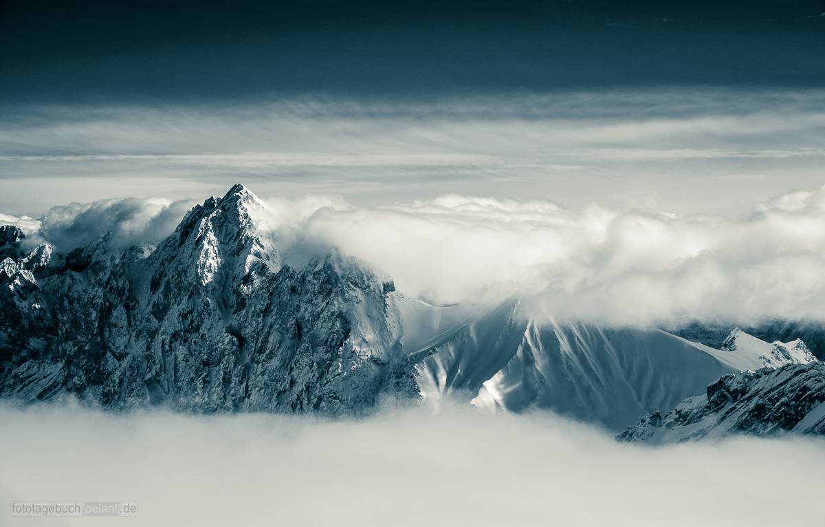 mountains between clouds