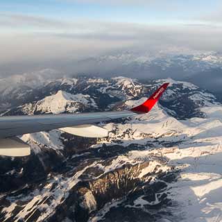 aerial view of snow-covered Chablais Alps in winter, viewed from Helvetic Airways Embraer 190 airplane during short flight from Sion to Zuerich
