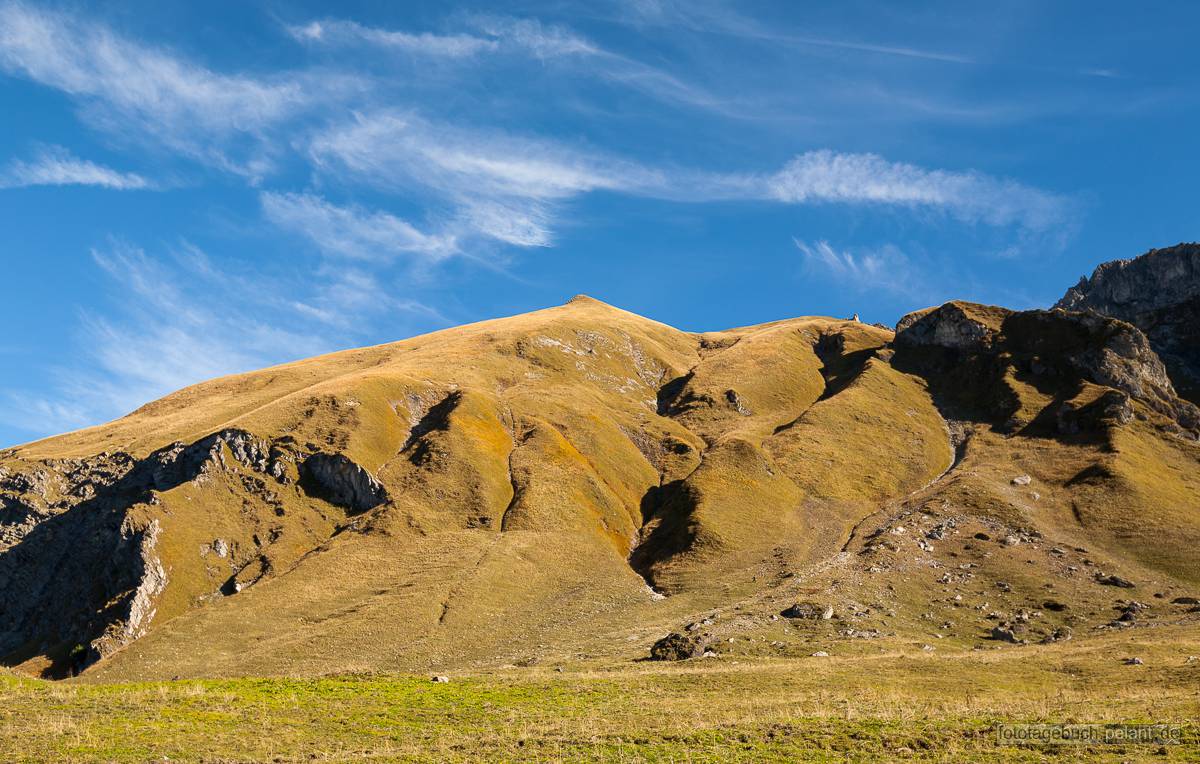 Berge mit gelbem Gras und blauem Himmel Berge mit gelbem Gras und blauem Himmel